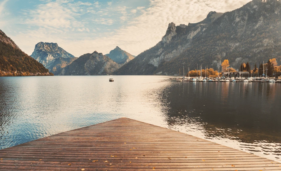Steg führt auf einen See umringt von Bergen