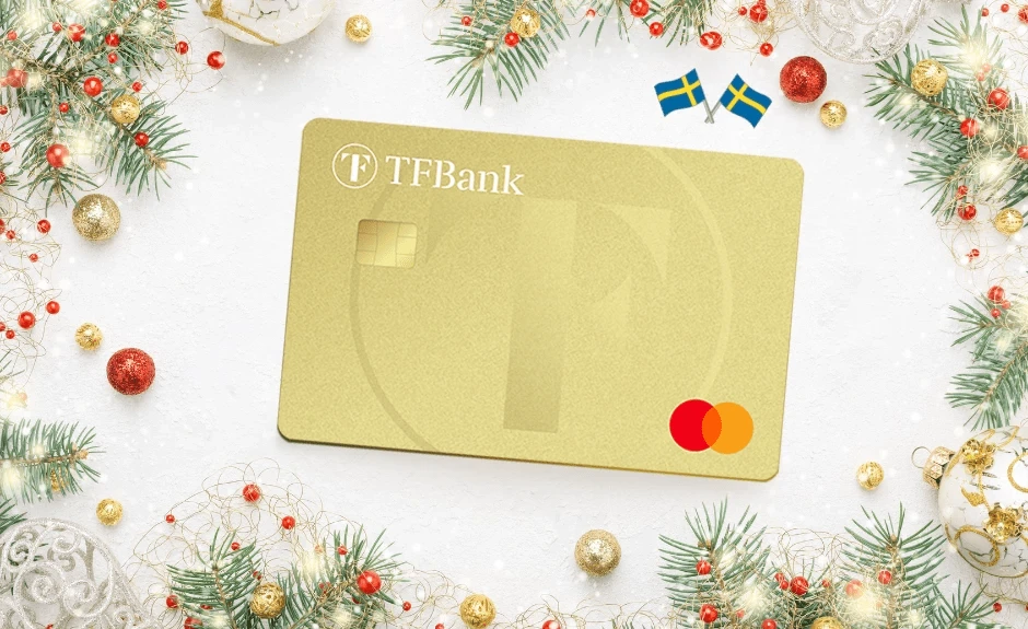 TF Mastercard Gold umgeben von Tannenzweigen und Weihnachtsdekoration und zwei schwedischen Fahnen