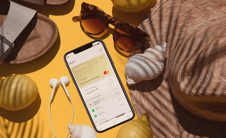 Die TF Mobile App auf einem Smartphone neben einer Sonnenbrille